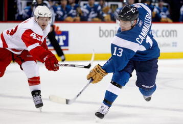 MONTREAL- NOVEMBER 21:  Mike Cammalleri #13 of the Montreal Canadiens takes a shot while being defended by Darren Helm #43 of the Detroit Red Wings during the NHL game on November 21, 2009 at the Bell Centre in Montreal, Quebec, Canada.  The Red Wings defeated the Canadiens 3-2 in a shootout.  (Photo by Richard Wolowicz/Getty Images)