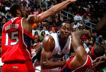 ATLANTA - NOVEMBER 26:  Al Horford #15 of the Atlanta Hawks defends as Josh Smith #5 draws a foul from Dwight Howard #12 of the Orlando Magic at Philips Arena on November 26, 2009 in Atlanta, Georgia.  (Photo by Kevin C. Cox/Getty Images)