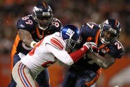 DENVER - NOVEMBER 26:  Knowshon Moreno #27 of the Denver Broncos rushes for a first down before being tackled by Corey Webster #23 of the New York Giants as Daniel Graham #89 of the Broncos blocks during NFL action at Invesco Field at Mile High on November 26, 2009 in Denver, Colorado. The Broncos defeated the Giants 26-6.  (Photo by Doug Pensinger/Getty Images)