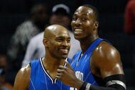 CHARLOTTE, NC - NOVEMBER 10:  Teammates Vince Carter #15 and Dwight Howard #12 of the Orlando Magic smile as they look over at the bench against the Charlotte Bobcats during their game at Time Warner Cable Arena on November 10, 2009 in Charlotte, North Carolina.  (Photo by Streeter Lecka/Getty Images)