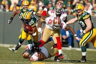 GREEN BAY, WI - NOVEMBER 22: Running back Ryan Grant #25 of the Green Bay Packers runs with the football as he is grabbed by linebacker Patrick Willis #25 and defensive back Tarell Brown #25 of the San Francisco 49ers at Lambeau Field on November 22, 2009 in Green Bay, Wisconsin. The Packers defeated the 49ers 30-24. (Photo by Scott Boehm/Getty Images)