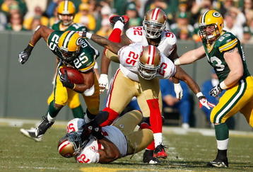 GREEN BAY, WI - NOVEMBER 22: Running back Ryan Grant #25 of the Green Bay Packers runs with the football as he is grabbed by linebacker Patrick Willis #25 and defensive back Tarell Brown #25 of the San Francisco 49ers at Lambeau Field on November 22, 2009 in Green Bay, Wisconsin. The Packers defeated the 49ers 30-24. (Photo by Scott Boehm/Getty Images)