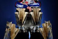 HOMESTEAD, FL - NOVEMBER 22: Jimmie Johnson, driver of the #48 Lowe's Chevrolet, poses with all four of his championship trophies after winning the NASCAR Sprint Cup Series Championship at Homestead-Miami Speedway on November 22, 2009 in Homestead, Florida. Johnson becomes the first driver in the history of NASCAR to win four consecutive championships since the sports inception in 1949. (Photo by Rusty Jarrett/Getty Images for NASCAR)