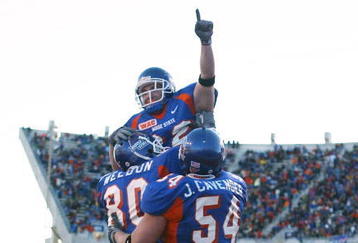 BOISE, ID - NOVEMBER 20:  Running back Jon Helmandollar #33 of Boise State is hoisted up by teammates Andy Weldon #80 and Jeff Cavender #54 after scoring a touchdown in the fourth quarter against Louisiana Tech at Bronco Stadium on November 20, 2004 in Boise, Idaho. Boise State defeated Louisiana Tech 55-14. (Photo by Jeff Gross/Getty Images)