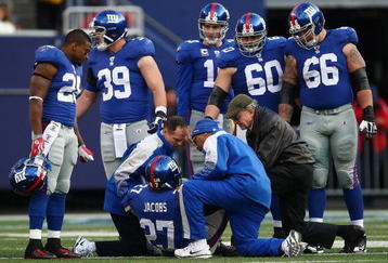 EAST RUTHERFORD, NJ - NOVEMBER 22: Team mates watch on as medical staff attend to Brandon Jacobs #27 of the New York Giants after he injured himself in a tackle against the Atlanta Falcons on November 22, 2009 at Giants Stadium in East Rutherford, New Jersey.  (Photo by Chris McGrath/Getty Images)