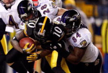PITTSBURGH - JANUARY 18:  Edgar Jones #84 and  Tom Zbikowski #28 of the Baltimore Ravens tackle Santonio Holmes #10 of the Pittsburgh Steelers on a punt return during the AFC Championship game on January 18, 2009 at Heinz Field in Pittsburgh, Pennsylvania.  (Photo by Streeter Lecka/Getty Images)