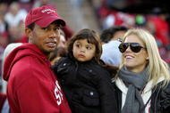 PALO ALTO, CA - NOVEMBER 21:  Honorary Standford Cardinal captain Tiger Woods holds his daugher, Sam, and stands next to his wife, Elin Nordegren, on the sidelines before the Cardinal game against the California Bears at Stanford Stadium on November 21, 2009 in Palo Alto, California.  (Photo by Ezra Shaw/Getty Images)