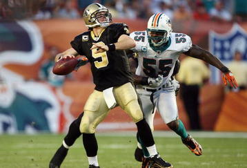 MIAMI - OCTOBER 25:  Quarterback Drew Brees #9 of the New Orleans Saints throws a pass before being hit by linebacker Joey Porter #55 of the Miami Dolphins at Land Shark Stadium on October 25, 2009 in Miami, Florida. The Saints defeated the Dolphins 46-34.  (Photo by Doug Benc/Getty Images)
