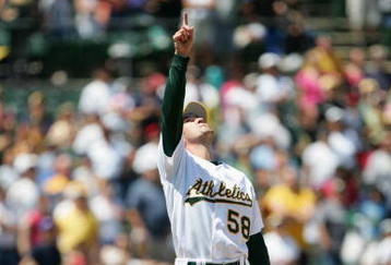 OAKLAND, CA - JUNE 18:  Pitcher Justin Duchscherer #58 of the Oakland Athletics points to the sky during the game against the Philadelphia Phillies at McAfee Coliseum on June 18, 2005 in Oakland, California.  The Athletics won 2-1.  (Photo by Jed Jacobsohn/Getty Images)