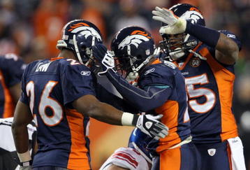 DENVER - NOVEMBER 26:  Andre Goodman #21 (C) of the Denver Broncos is congratulated by Ty Law #26 and DJ Williams #55 after his fourth quarter interception of quarterback Eli Manning of the New York Giants during NFL action at Invesco Field at Mile High on November 26, 2009 in Denver, Colorado. The Broncos defeated the Giants 26-6.  (Photo by Doug Pensinger/Getty Images)