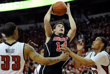 LAS VEGAS - NOVEMBER 28:  Kyle Kuric #14 of the Louisville Cardinals shoots over Tre'Von Willis #33 and Chace Stanback #22 of the UNLV Rebels during their game at the Thomas & Mack Center November 28, 2009 in Las Vegas, Nevada. The Rebels Defeated the Cardinals 76-71.  (Photo by Ethan Miller/Getty Images)