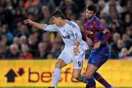 BARCELONA, SPAIN - NOVEMBER 29: Cristiano Ronaldo (L) of Real Madrid duels for the ball with Gerard Pique of FC Barcelona during the La Liga match between Barcelona and Real Madrid at the Camp Nou Stadium on November 29, 2009 in Barcelona, Spain. Barcelona won the match 1-0. (Photo by Jasper Juinen/Getty Images)