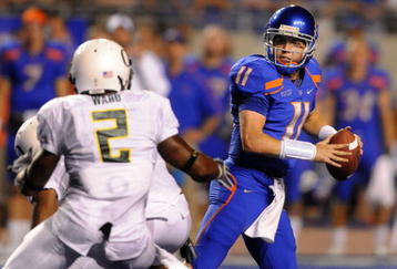 BOISE, ID - SEPTEMBER 3:  Kellen Moore #11 of the Boise State throws a pass under pressure by T.J. Ward #2 of the Oregon Ducks in second quarter of the game on September 3, 2009 at Broncos Stadium in Boise, Idaho. Boise State won the game 19-8. (Photo by Steve Dykes/Getty Images)