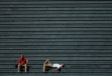 DENVER - SEPTEMBER 18:  Two fans in the vacant centerfield bleachers bask in the warm sun on a late summer afternoon as the Colorado Rockies host the Los Angeles Dodgers at Coors Field on September 18, 2007 in Denver, Colorado. The Rockies defeated the Dodgers 3-1 in the first game of a double header.  (Photo by Doug Pensinger/Getty Images)