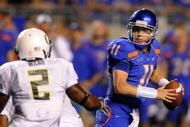 BOISE, ID - SEPTEMBER 3:  Kellen Moore #11 of the Boise State throws a pass under pressure by T.J. Ward #2 of the Oregon Ducks in second quarter of the game on September 3, 2009 at Broncos Stadium in Boise, Idaho. Boise State won the game 19-8. (Photo by Steve Dykes/Getty Images)