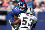 EAST RUTHERFORD, NJ - OCTOBER 11: Brandon Jacobs #27 of the New York Giants runs through Thomas Howard #53 of the Oakland Raiders during the game on October 11, 2009 at Giants Stadium in East Rutherford, New Jersey.  (Photo by Jared Wickerham/Getty Images)