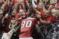 HOUSTON - NOVEMBER 23:  Wide receiver Andre Johnson #80 of the Houston Texans jumps into the crowd after scoring a touchdown in the second quarter against the Tennessee Titans at Reliant Stadium on November 23, 2009 in Houston, Texas.  (Photo by Bob Levey/Getty Images)