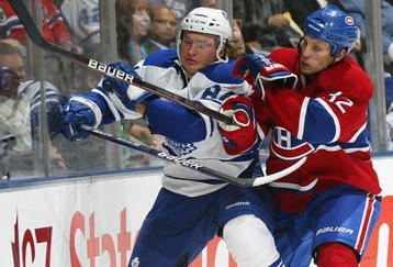TORONTO, ON - OCTOBER 1:  Travis Moen #32 of the Montreal Canadiens battles with Mikhail Grabovski #84 of the Toronto Maple Leafs for puck posession in a game on October 1, 2009 at the Air Canada Centre in Toronto, Ontario. The Canadiens dfeated the Leafs 4-3 in overtime. (Photo by Claus Andersen/Getty Images)