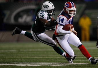 EAST RUTHERFORD, NJ - OCTOBER 18: Ryan Fitzpatrick #14 of the Buffalo Bills runs out of the pocket from David Harris #52 of the New York Jets during the game on October 18, 2009 at Giants Stadium in East Rutherford, New Jersey. The Bills defeated the Jets 16-13 in overtime. (Photo by Jared Wickerham/Getty Images) 