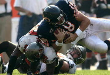 CHICAGO - SEPTEMBER 21:  Quarterback Kyle Orton #18 of the Chicago Bears is is hit by Cato June #59 of the Tampa Bay Buccaneers at Soldier Field on September 21, 2008 in Chicago, Illinois.  (Photo by Jonathan Ferrey/Getty Images)