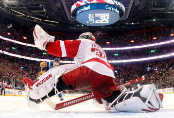 MONTREAL- NOVEMBER 21:  Jimmy Howard #35 of the Detroit Red Wings stretches out to stop the puck on the shootout attempt by Mike Cammalleri #13 of the Montreal Canadiens during the NHL game on November 21, 2009 at the Bell Centre in Montreal, Quebec, Canada.  The Red Wings defeated the Canadiens 3-2 in a shootout.  (Photo by Richard Wolowicz/Getty Images)
