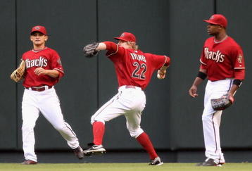 PHOENIX - JUNE 23:  Outfielder Eric Byrnes #22 of the Arizona Diamondbacks fields a triple hit by Michael Young #10 of the Texas Rangers (not pictured) as Gerardo Parra #9 and Justin Upton #10 look on during the first inning of the major league baseball game at Chase Field on June 23, 2009 in Phoenix, Arizona.  (Photo by Christian Petersen/Getty Images)