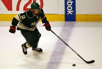 CHICAGO - OCTOBER 26: Chuck Kobasew #12 of the Minnesota Wild handles the puck against the Chicago Blackhawks at the United Center on October 26, 2009 in Chicago, Illinois. The Blackhawks defeated the Wild 3-1. (Photo by Jonathan Daniel/Getty Images)