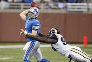 DETROIT , MI - NOVEMBER 01: Mathew Stafford #9 of the Detroit Lions tries to get a pass of before being tackled by James Hall #96 of the St. Louis Rams on November 1, 2009 at Ford Field in Detroit, Michigan. (Photo by Gregory Shamus/Getty Images)