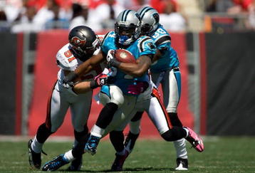 TAMPA, FL - OCTOBER 18:  Running back DeAngelo Williams #34 of the Carolina Panthers is tackled by defenders Barrett Ruud #51 and Ronde Barber #20 of the Tampa Bay Buccaneers during the game at Raymond James Stadium on October 18, 2009 in Tampa, Florida.  (Photo by J. Meric/Getty Images)