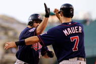 ANAHEIM, CA - JULY 23:  Jason Kubel #16 of the Minnesotta Twins is congratulated by teammate Joe Maur #7 after hitting a two-run home run off pitcher Jered Weaver #36 of the Los Angeles Angels of Anaheim during the first inning of the baseball game on July 23, 2009 in Anaheim, California.  mauer scored on the home run.  (Photo by Kevork Djansezian/Getty Images)