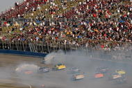 FONTANA, CA - OCTOBER 11:  Cars crash going into turn one in the final laps of the NASCAR Sprint Cup Series Pepsi 500 at Auto Club Speedway on October 11, 2009 in Fontana, California.  (Photo by Chris Graythen/Getty Images)