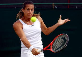 WIMBLEDON, ENGLAND - JUNE 27:  Amelie Mauresmo of France plays a backhand during the women's singles third round match against Flavia Pennetta of Italy on Day Six of the Wimbledon Lawn Tennis Championships at the All England Lawn Tennis and Croquet Club on June 27, 2009 in London, England.  (Photo by Ian Walton/Getty Images)