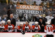 PITTSBURGH - MAY 18:  Assistant Coach Jack Mcllhargey and Head Coach John Stevens of the Philadelphia Flyers stand behind their team as Penguins fans hold a sign reading 'Orange Crushed' in the third period en route to the Pittsburgh Penguins win of game five of the Eastern Conference Finals of the 2008 NHL Stanley Cup Playoffs at Mellon Arena on May 18, 2008 in Pittsburgh, Pennsylvania.  The Penguins shut out the Flyers 6-0 and win the series 4-1 to advance to the Stanley Cup Finals. (Photo by Jim McIsaac/Getty Images)