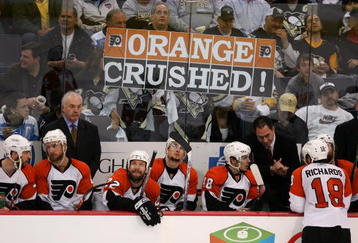 PITTSBURGH - MAY 18:  Assistant Coach Jack Mcllhargey and Head Coach John Stevens of the Philadelphia Flyers stand behind their team as Penguins fans hold a sign reading 'Orange Crushed' in the third period en route to the Pittsburgh Penguins win of game five of the Eastern Conference Finals of the 2008 NHL Stanley Cup Playoffs at Mellon Arena on May 18, 2008 in Pittsburgh, Pennsylvania.  The Penguins shut out the Flyers 6-0 and win the series 4-1 to advance to the Stanley Cup Finals. (Photo by Jim McIsaac/Getty Images)