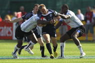 DUBAI, UNITED ARAB EMIRATES - DECEMBER 04:  Andrew Turnbull of Scotland is tackled by the Fiji defence during the IRB Sevens tournament at the Dubai Sevens Stadium on December 4, 2009 in Dubai, United Arab Emirates.  (Photo by David Rogers/Getty Images)