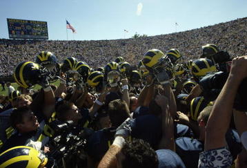 ANN ARBOR, MI - AUGUST 31:  The Michigan Wolverines hold up their helmets in victory after the clutch NCAA football game against the Washington Huskies at Michigan Stadium in Ann Arbor, Michigan on August 31, 2002. The Michigan Wolverines won on a last second field goal, 31-29.  (Photo by Tom Pidgeon /Getty Images)
