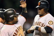 PHOENIX - SEPTEMBER 23:  Juan Uribe #5 of the San Francisco Giants is congratulated by teammate Pablo Sandoval #48 after Uribe hit a two-run home run against the Arizona Diamondbacks during the sixth inning of the major league baseball game at Chase Field on September 23, 2009 in Phoenix, Arizona.  (Photo by Christian Petersen/Getty Images)