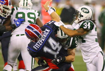 TORONTO - DECEMBER 3: Eric Smith #33 and Marquice Cole #34 of the New York Jets hit quarterback Ryan Fitzpatrick #14 of the Buffalo Bills as he throws the ball at Rogers Centre on December 3, 2009 in Toronto, Canada.  (Photo by Rick Stewart/Getty Images)