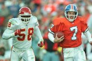 27 Oct 1996:  Quarterback John Elway of the Denver Broncos runs away from Derrick Thomas of the Kansas City Chiefs during the second half of the Broncos v Chiefs game at Mile High Stadium in Denver, Colorado. The Broncos won 34-7. Mandatory Credit: Jed Ja