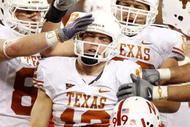 ARLINGTON, TX - DECEMBER 5:  Quarterback Colt McCoy #12 of the Texas Longhorns is congratulated by teammates after his touchdown run in the second quarter against the Nebraska Cornhuskers at Cowboys Stadium on December 5, 2009 in Arlington, Texas. (Photo by Ronald Martinez/Getty Images)