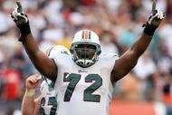 MIAMI - DECEMBER 06:  Tackle Vernon Carey #72 of the Miami Dolphins celebrates after linebacker Channing Crowder #52 intercepted quarterback Tom Brady #12 of the New England Patriots at Land Shark Stadium on December 6, 2009 in Miami, Florida. The Dolphins defeated the Patriots 22-21.  (Photo by Doug Benc/Getty Images)