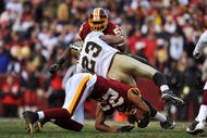 LANDOVER, MD - DECEMBER 6: Pierre Thomas #23 of the New Orleans Saints is stopped by Carlos Rogers #22 of the Washington Redskins at FedExField on December 6, 2009 in Landover, Maryland. The Saints defeated the Redskins in overtime 33-30. (Photo by Larry French/Getty Images)
