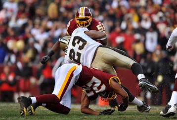 LANDOVER, MD - DECEMBER 6:  Pierre Thomas #23 of the New Orleans Saints is stopped by Carlos Rogers #22 of the Washington Redskins at FedExField on December 6, 2009 in Landover, Maryland. The Saints defeated the Redskins in overtime 33-30. (Photo by Larry French/Getty Images)