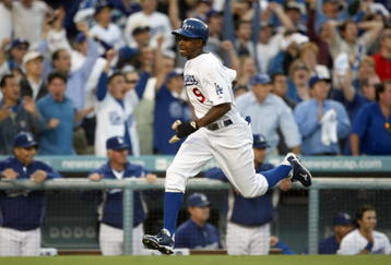 LOS ANGELES, CA - OCTOBER 08:  Juan Pierre #9 of the Los Angeles Dodgers scores the game-tying run in the ninth inning on a single by Ronnie Belliard #3 against the St. Louis Cardinals in Game Two of the NLDS during the 2009 MLB Playoffs at Dodger Stadium on October 8, 2009 in Los Angeles, California. The Dodgers defeated the Cardinals 3-2 to take a 2-0 series lead.  (Photo by Stephen Dunn/Getty Images)