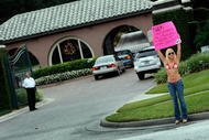 WINDERMERE, FL - DECEMBER 02:   MJ Radio show personality Meredith Walusek holds a sign reading, 'Tiger- They offered  me $500,000- I�m keeping my mouth shut!', in front of a gate to the Isleworth community where Tiger Woods has a home on December 2, 2009 in Windermere, Florida. Tiger Woods crashed his SUV into a fire hydrant and tree next to his Florida home in the early hours of November 27. FHP charged Woods with careless driving which carries a $164 fine and four points on his driving record. Woods released a statement on his website stating, 'I have let my family down and I regret those transgressions with all of my heart.'.  (Photo by Joe Raedle/Getty Images)