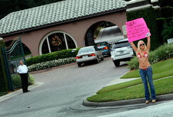 WINDERMERE, FL - DECEMBER 02:   MJ Radio show personality Meredith Walusek holds a sign reading, 'Tiger- They offered  me $500,000- I�m keeping my mouth shut!', in front of a gate to the Isleworth community where Tiger Woods has a home on December 2, 2009 in Windermere, Florida. Tiger Woods crashed his SUV into a fire hydrant and tree next to his Florida home in the early hours of November 27. FHP charged Woods with careless driving which carries a $164 fine and four points on his driving record. Woods released a statement on his website stating, 'I have let my family down and I regret those transgressions with all of my heart.'.  (Photo by Joe Raedle/Getty Images)