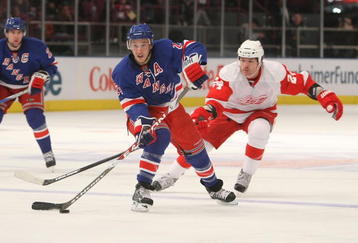 NEW YORK - DECEMBER 06:  Ryan Callahan #24 of the New York Rangers passes the puck under pressure from Brad May #24 of  the Detroit Red Wings on December 6, 2009 at Madison Square Garden in New York City.  (Photo by Nick Laham/Getty Images)