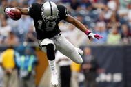 HOUSTON - OCTOBER 04: Wide receiver Louis Murphy #18 of the Oakland Raiders jumps over a tackle by the Houston Texans at Reliant Stadium on October 4, 2009 in Houston, Texas. (Photo by Ronald Martinez/Getty Images)