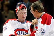 MONTREAL- DECEMBER 4:  Former Montreal Canadiens Serge Savard hands a puck to Patrick Roy during the Centennial Celebration ceremonies prior to the NHL game between the Montreal Canadiens and Boston Bruins on December 4, 2009 at the Bell Centre in Montreal, Quebec, Canada.  The Canadiens defeated the Bruins 5-1.  (Photo by Richard Wolowicz/Getty Images)