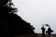 SYDNEY, AUSTRALIA - DECEMBER 01: Golfers make their way back to the clubhouse after rain sets in during a practice round ahead of the Australian Open Golf Championship at New South Wales Golf Club, La Perouse on December 1, 2009 in Sydney, Australia. (Photo by Craig Golding/Getty Images)